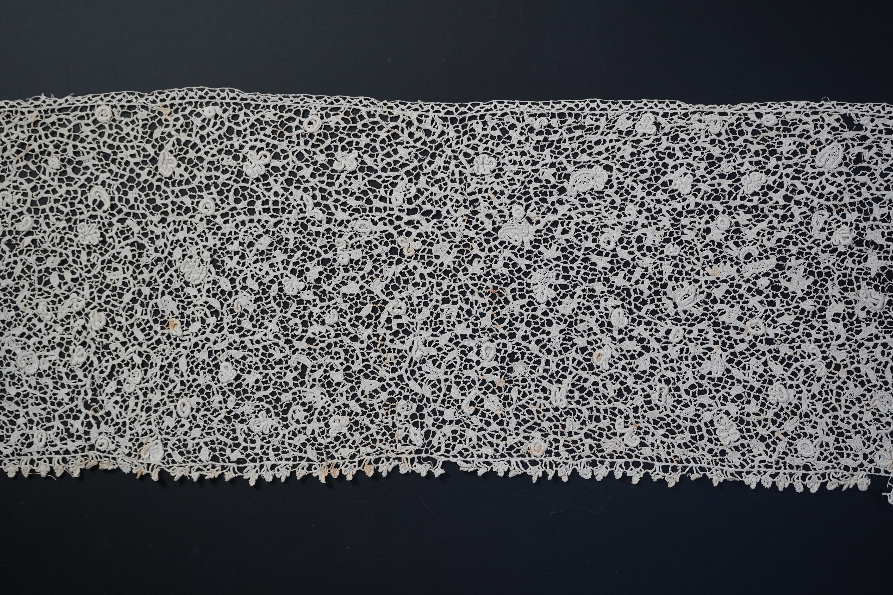 A late 17th century wide flounce of Point de France needle lace, together with a narrower flounce, both with raised elements of the design in the style of Point de Rose, but less so. This lace was very popular with the F